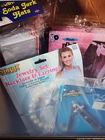 Various costume accessories including a Spirit brand pearl necklace and earrings set, soda jerk hats, and Era leggings packaging visible.