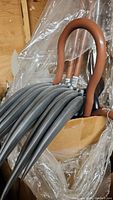Photo shows a close-up of plastic scythe blades stacked together and the brown curved handle of a shepherd hook staff.