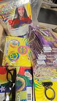 Image showing packaged hippie kits including glasses with peace symbol, colorful buttons, and teeth accessory items laid out in a box.