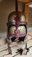 Dragon-themed medieval helmet with gold and red dragon decoration