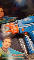 Blue and orange Star Trek Phaser toy gun in original packaging showing character image and branding.