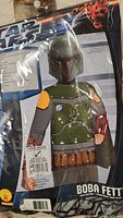 Plastic-wrapped large size Boba Fett kids costume showing full costume with armor print and helmet design on package