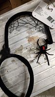 Black spider headband featuring a spider and web design on display with tag attached