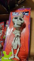 Close up of skeleton novelty keychain in original packaging showing skeleton with movable joints.