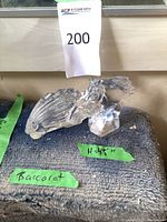 Two crystal sculptures on cloth surface with lot number and green tape label