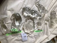 Overall view of seven crystal animal sculptures displayed on fabric