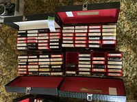 Collection of four open 8-track tape cases with tapes inside, arranged on a carpet.