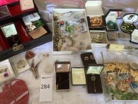 Overview of assorted vintage jewelry pieces in boxes and trays