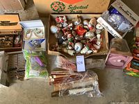 Overview of lot contents on floor: jewelry boxes, box of ornaments, folding fans.