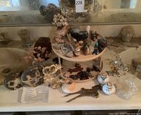 Wide view of the lot displaying the stone animals, earrings on wooden turntable shelf, and additional brass and glass decor pieces.