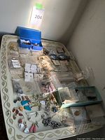 Overview of white folding tray with scattered jewelry pieces on top, tray leaning against wall