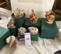 Overview of seven Harmony Kingdom trinket boxes on display, some still packaged and boxed