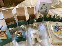 Various Harmony Kingdom trinket boxes and figurines displayed on green boxes alongside Wild Bill's boot cup and space shuttle plate.