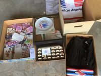 Overall view of boxes showing Olympic pins, plates, sweaters, sandals, and other memorabilia