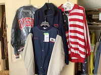 Photo showing all three jackets together on hangers, displaying their patriotic and Olympic themes.