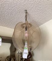 Overall view of pendant lamp hanging from ceiling chain, showing shade shape and included bulb