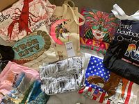 Group shot of seven T-shirts and two tote bags laid out