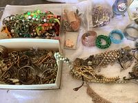 Overview of assorted vintage costume jewelry showing multiple bead necklaces, bracelets, and bangles in various colors and materials.