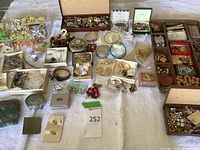 Overview on white cloth showing multiple trays and loose jewelry pieces