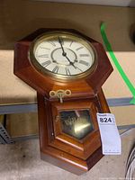 Overall view of the wooden regulator clock showing the octagonal face and lower glass door with 'Regulator' inscription.