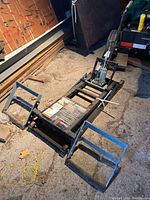 Full view of black steel scissor lift frame with ramp platforms attached, placed on concrete floor.