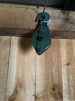 Front view of pulley block showing green metal body and hook with quick release