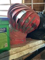 Overview of red metal turbine roof vent with visible peeling paint and some rust marks.