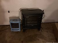 Photo of both electric fireplace style heaters, showing size comparison and colors (black and robin egg blue).