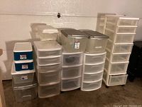 Full view of all assorted plastic bins and drawer units showing different sizes and shapes, stacked and arranged side by side.