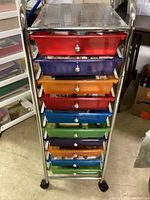 Full view of tall metal rolling drawer organizer with 10 colorful drawers in red, blue, green, purple, and orange.