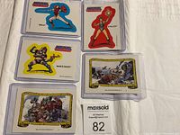 Five Masters of the Universe cards with character cards and action scene cards displayed in protective sleeves on a white surface.