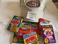 Overall contents including Phillies cap and 7 unopened baseball card packs.