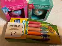 Photo of two bubble bombs in original packaging (Unicorn and Mermaid themes) and a box of Crayola Bathtub Crayons with 10 colored crayons.