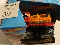 Close-up photo of Hot Wheels Rev Tredz Monster Truck toy in original box with packaging tears visible.