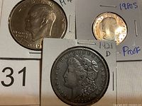 Front side of 1976 Eisenhower Dollar, 1980 S Susan B. Anthony Proof Dollar, 1921 D Morgan Silver Dollar.
