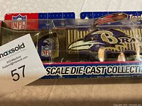 Photo showing front and side of die-cast Baltimore Ravens tractor-trailer in original packaging with NFL and Ravens logos visible.
