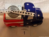 Ceramic truck painted with US flag holding stack of coin flips