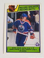 Front of 1983-84 OPC Wayne Gretzky Record Breaker Card showing Gretzky in Edmonton Oilers uniform with NHL and Record Breaker label, card number 212.