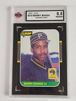 Front side of 1987 Leaf #219 Barry Bonds rookie card in hard plastic graded case showing the label with grade 8.5 NMM+ by KSA
