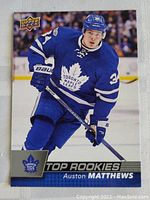 Front of the 2017 Upper Deck Auston Matthews rookie card showing the player in action in Toronto Maple Leafs uniform.