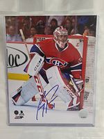 Front view of autographed photo of Carey Price in Canadiens uniform in front of goal net with autograph on bottom center.