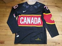 Front view of black Team Canada hockey jersey showing CANADA logo and maple leaf details with Nike logo and mesh sides