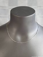 Full view of the sterling silver box chain necklace displayed on a gray mannequin bust showing length and drape.