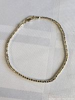 Full view of the sterling silver bracelet laid flat on fabric background showing entire chain and clasp.