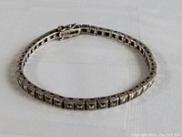 Full view of the sterling silver bracelet arranged in a circular layout showing overall design and clasp.