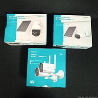 Three retail boxes: two Dekco Solar Wireless Security Camera boxes and one Dekco HD WiFi Security Camera 2CH box