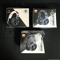 Three boxed OneOdio DJ headphones models placed on black surface: Fusion, Studio Pro 10, and 10 Studio.