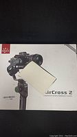 Front of product box showing Moza AirCross 2 gimbal with mounted camera