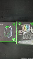Photo showing the front of boxed Razer Kaira headset and Tartarus Pro keypad on dark background.