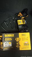 DeWalt charger and power cord with product box showing Atomic 20V label and features.